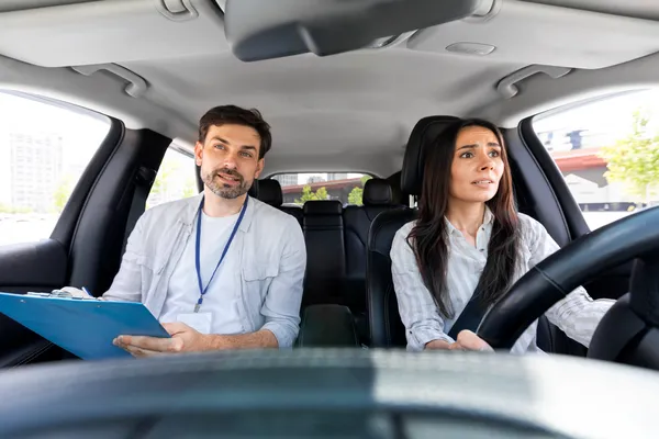 Una mujer nerviosa manejando un auto, a un lado un instructor de cursos de manejo VERTIZ especializado en personas nerviosas 